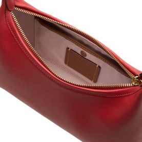 Coach leather crossbody bag in Poppy red, open to show blush pink interior lining and card slot, gold-tone zip hardware