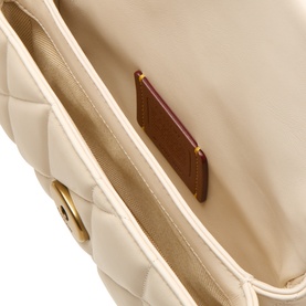 Coach chalk quilted leather crossbody bag interior, showing card slot and brown leather lining detail with gold-tone hardware