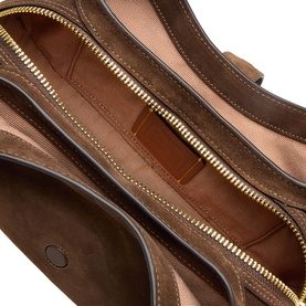 Coach dark chocolate leather shoulder bag interior view, showing gold-tone zip, tan fabric lining and multiple compartments.