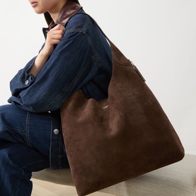 Model carrying Coach Brooklyn 39 Suede Shoulder Bag in Dark Chocolate; large structured silhouette with gold-toned hardware, styled with denim jacket