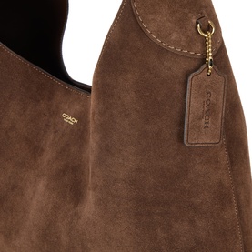 Coach brown suede hobo bag with gold-tone hardware and hanging Coach logo luggage tag charm, close-up detail view