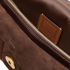 Coach dark chocolate suede shoulder bag interior, showing gold-tone zip pocket and branded leather patch lining detail