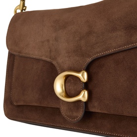 Coach Tabby shoulder bag in brown suede with gold-tone C clasp hardware and flap closure, close-up detail view