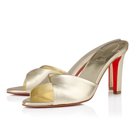 Christian Louboutin mule heels in platine metallic leather with open toe, crossover strap, and signature red sole.