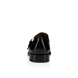 Christian Louboutin black patent leather monk strap shoe, heel view showing signature red sole and buckle detail