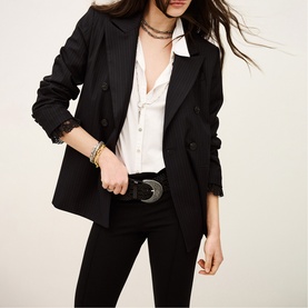 Model wearing Bash blue blazer with white blouse, black skinny trousers and western belt, gold bracelet
