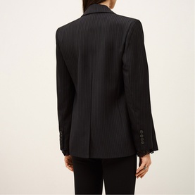 Model wearing Bash blue pinstripe blazer, back view, with black tailored trousers. Button cuff detail visible.