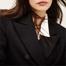 Model wearing Bash blue pinstripe blazer with white shirt and delicate chain necklace