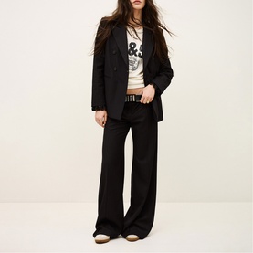 Model wearing Bash Womens French Dress in blue, styled with a graphic tee, wide-leg trousers, belt, and flat shoes.