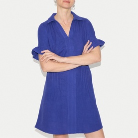 Model wearing Jigsaw blue mini shirt dress with V-neckline, collar, and short flutter sleeves, in an A-line silhouette