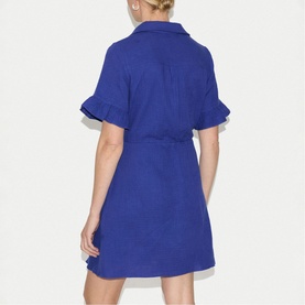 Model wearing Jigsaw blue short-sleeve shirt dress with ruffle cuffs and self-tie belted waist, back view.