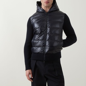 Model wearing Moncler navy cardigan with quilted down gilet front panel and hood, styled with matching navy trousers