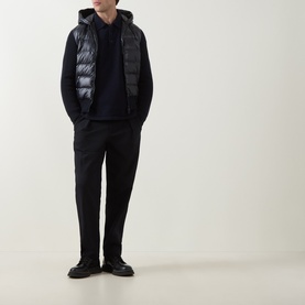 Model wearing Moncler navy cardigan with quilted gilet overlay, styled with black trousers and chunky leather shoes
