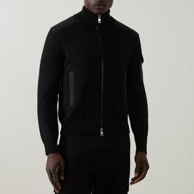 Model wearing Moncler black zip-through cardigan with contrast leather panels on shoulders and chest pocket detail