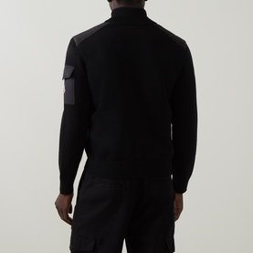 Model wearing Moncler black cardigan, rear view showing contrast panel shoulder detail and utility pocket in dark grey tonal finish.