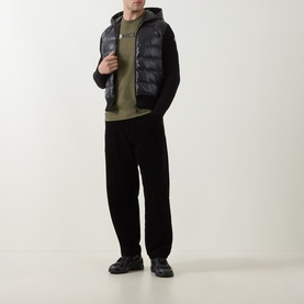 Model wearing Moncler black down-panel cardigan with khaki hoodie, black wide-leg trousers and black chunky shoes