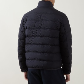 Model wearing Moncler navy quilted down jacket, rear view, with matching navy trousers visible