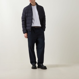 Model wearing Moncler navy quilted down jacket with white T-shirt, navy trousers and black leather shoes.