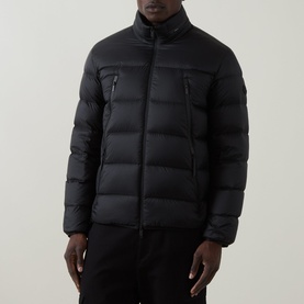 Model wearing Moncler black quilted down jacket with zip chest pockets and funnel neck, styled with black trousers