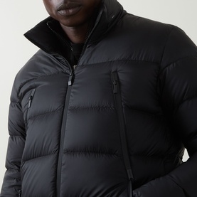 Model wearing Moncler black quilted down puffer jacket with funnel neck, zip chest pocket and centre-front zip fastening