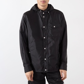 Model wearing Moncler black polyamide hooded overshirt jacket with snap buttons and chest pocket, styled with dark trousers