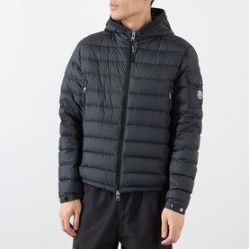 Model wearing Moncler Galion Short Down Jacket in black, quilted finish with hood, full zip-through fastening and logo badge on left sleeve