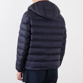 Model wearing Moncler dark blue quilted hooded down jacket, rear view, styled with navy trousers.