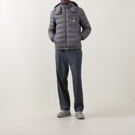 Model wearing Moncler grey quilted down jacket with detachable hood, styled with grey trousers and chunky trainers