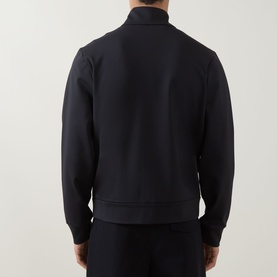 Model wearing Moncler dark blue sweatshirt, rear view showing ribbed cuffs, hem, and stand collar with zip fastening.