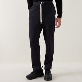 Model wearing Moncler dark blue sweatpants with cream drawstring waist, paired with black knit top and chunky trainers.