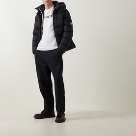 Model wearing Moncler natural cotton T-shirt, styled with black puffer jacket, black trousers and black boots.