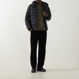 Model wearing Moncler dark green T-shirt, styled with black quilted hooded jacket, black trousers and black shoes.