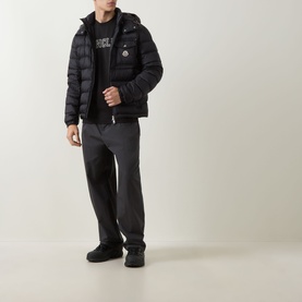 Model wearing Moncler black cotton T-shirt, styled with black puffer jacket and grey joggers.