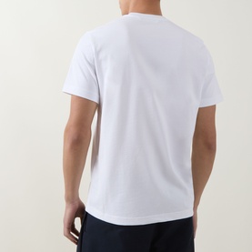 Model wearing Moncler white cotton T-shirt, rear view, styled with navy trousers.