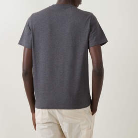 Model wearing Moncler dark grey cotton T-shirt, rear view, styled with light beige trousers