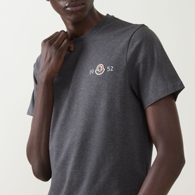 Model wearing Moncler dark grey cotton T-shirt with embroidered logo badge on chest, short sleeves and crew neckline