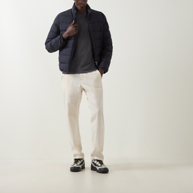 Model wearing Moncler dark grey T-shirt, styled with navy puffer jacket, cream trousers and chunky boots.