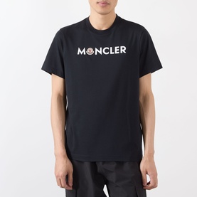 Model wearing Moncler Felt Logo Graphic T-Shirt in navy, crew neck with white chest logo, styled with black trousers.