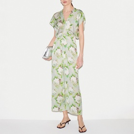 Model wearing Jigsaw green floral print midi dress with V-neck, styled with silver clutch bag and black strappy sandals.