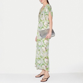 Model wearing Jigsaw green floral maxi dress with short sleeves, styled with silver clutch bag and black flat sandals