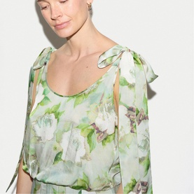 Model wearing Jigsaw green floral chiffon dress with tie shoulder detail and flutter sleeves, cropped view showing bodice.