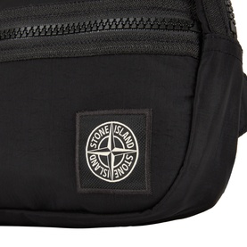 Stone Island black polyurethane bag, close-up showing zip detail and iconic compass rose logo badge