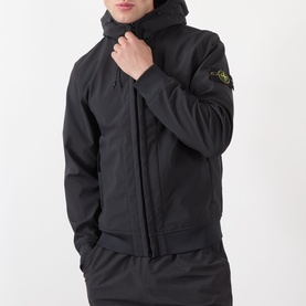 Model wearing Stone Island Soft Shell-R-e.dye&reg; Wind Resistant Jacket in black, with hood up, logo badge on left sleeve, zip fastening visible.