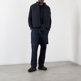 Model wearing Stone Island blue quilted casual jacket, styled with navy trousers and black loafers, full-length view