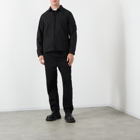 Model wearing Stone Island black casual shirt jacket with black trousers and black leather boots.