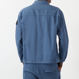 Model wearing Stone Island BLU ARDESIA cotton casual shirt, rear view, with signature compass badge on sleeve, styled with matching trousers