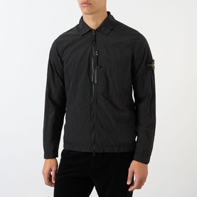 Model wearing Stone Island Logo Badge Zip Overshirt in black, with point collar, chest zip pocket and logo badge on sleeve.