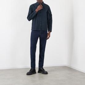 Model wearing Stone Island navy blue cotton casual shirt, styled with dark indigo jeans and black leather shoes