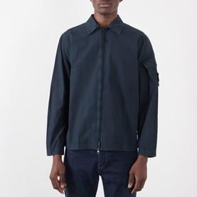 Model wearing Stone Island navy blue cotton casual shirt jacket with zip front, spread collar, and sleeve badge detail