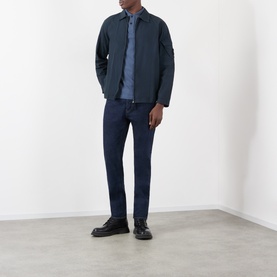 Model wearing Stone Island navy blue cotton casual shirt, styled with matching navy jacket and dark jeans, black loafers